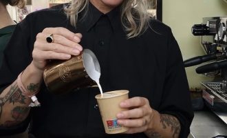 Freelance barista schenkt melk tijdens barista service van De Koffiejuf